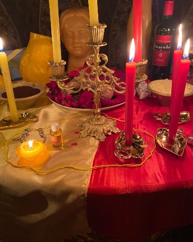 Altar com velas vermelhas e douradas em ritual da Clínica Reatar